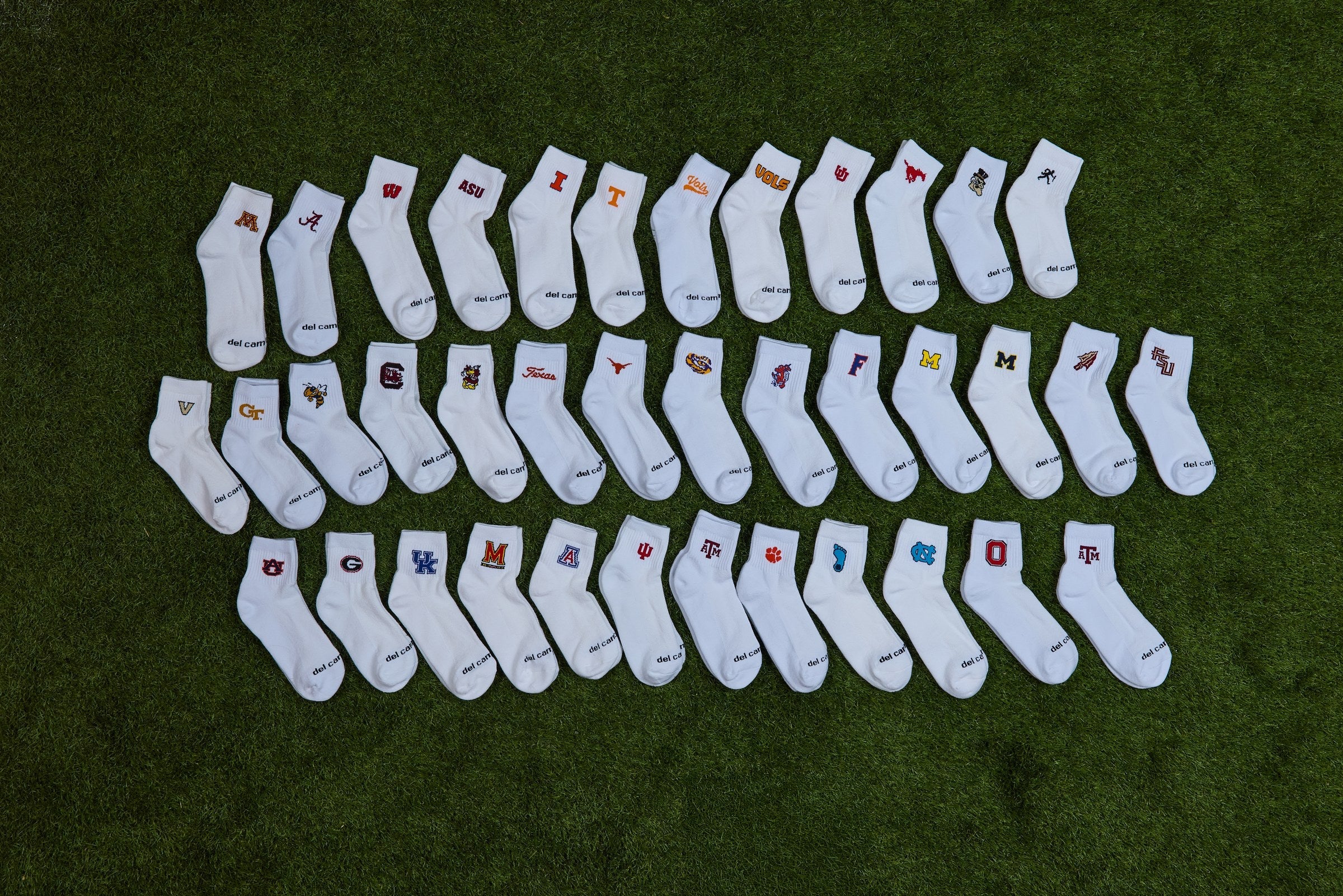 Del Campo officially licensed college socks laid out on turf