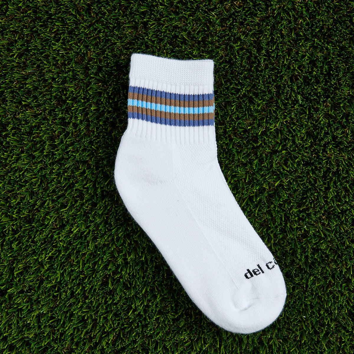 Del Campo Denim 5 Stripe golf socks, flat lay on grass