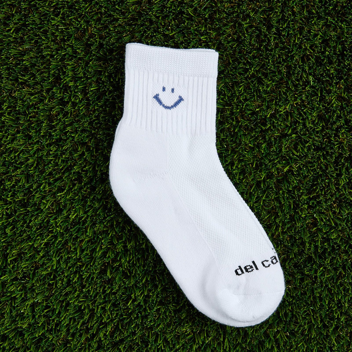 Del Campo Denim Smiley golf socks, flat lay on grass