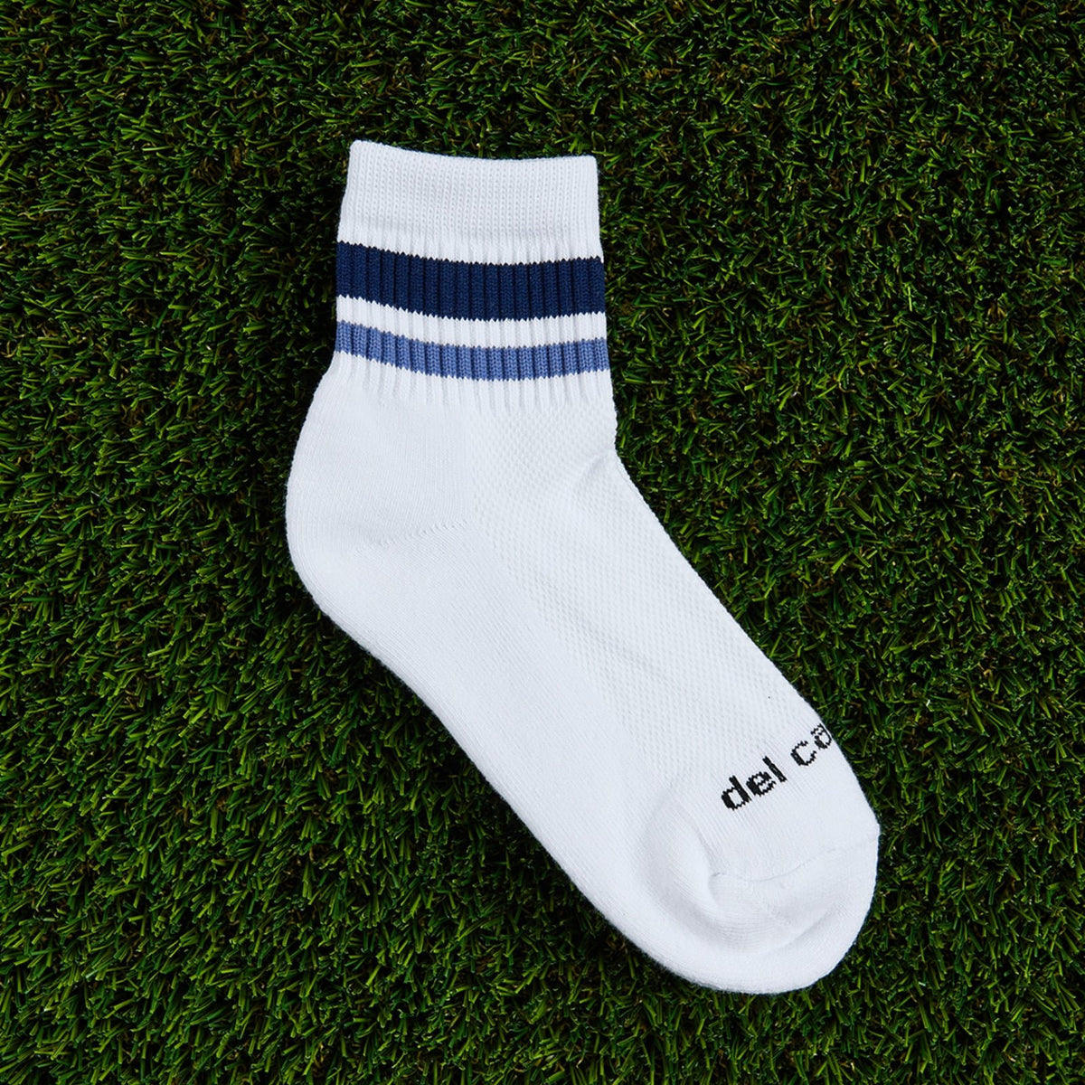 Del Campo Navy Stripes golf socks, flat lay on grass