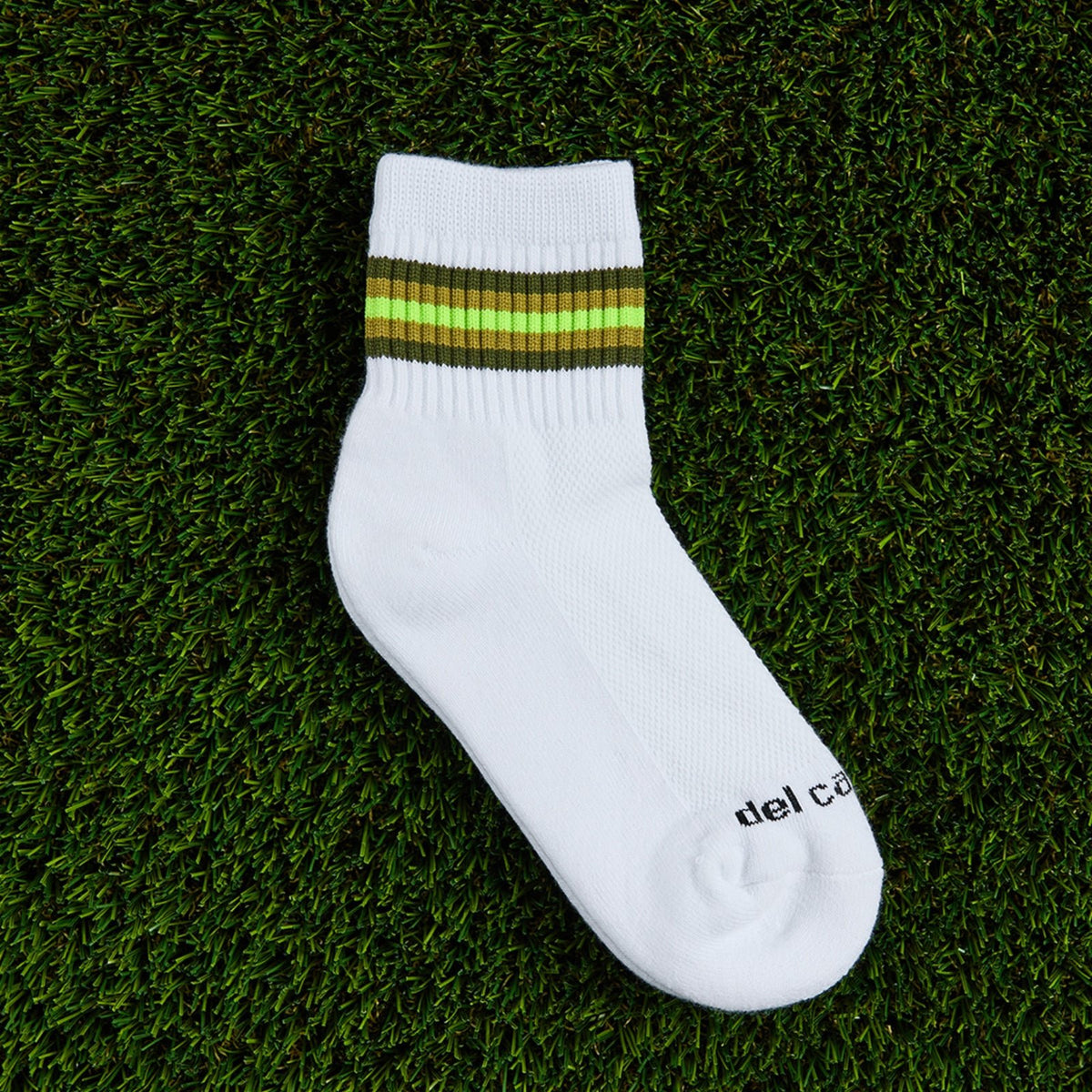 Del Campo Forest 5 Stripe golf socks, flat lay on grass