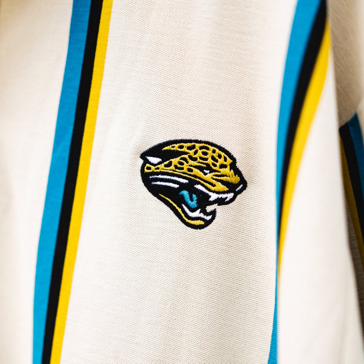 Lot J Polo, officially licensed Jacksonville Jaguars cream polo with teal and gold stripes by Del Campo