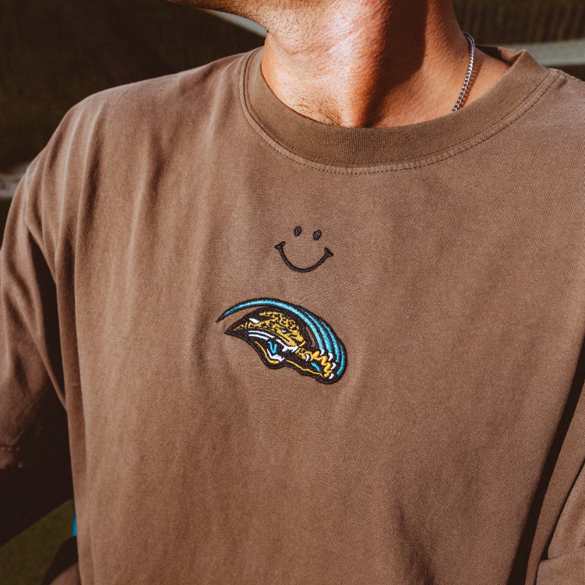 The Jags Tee, officially licensed Jacksonville Jaguars washed brown tee with smiley and Scratch logo by Del Campo