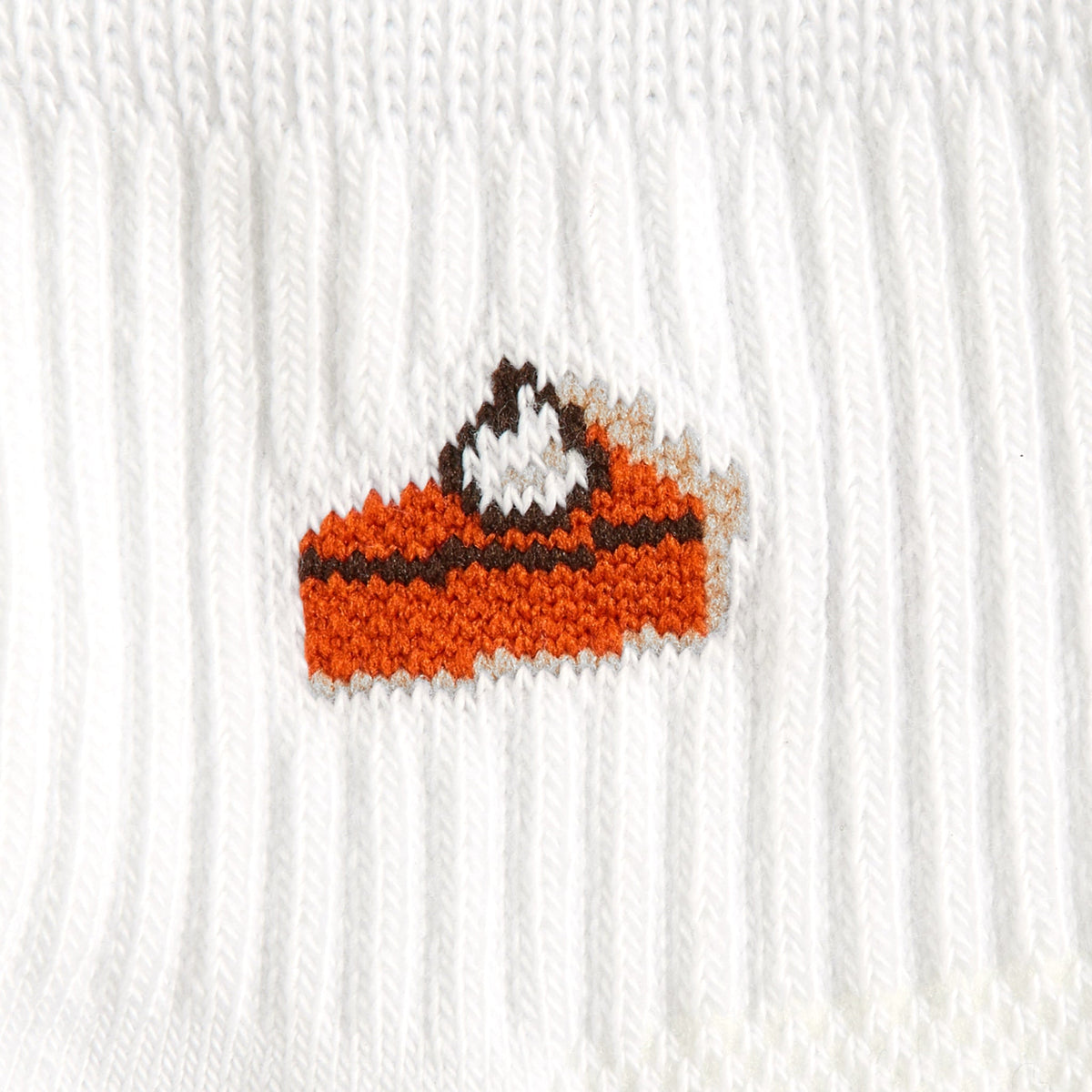 Del Campo Pumpkin Pie Thanksgiving golf socks, white quarter socks with a knit slice of pumpkin pie, close-up of the knit pie slice