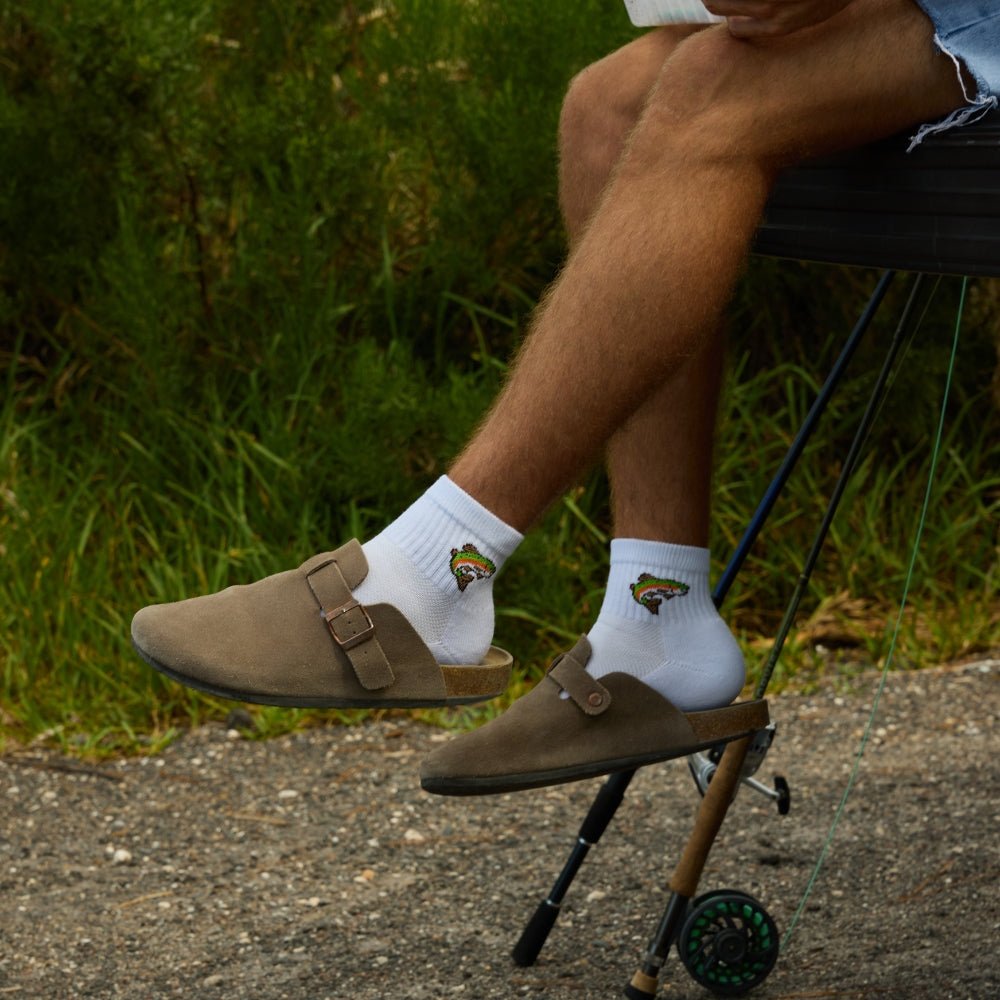Man in clogs seated outdoors wearing Del Campo Trout socks
