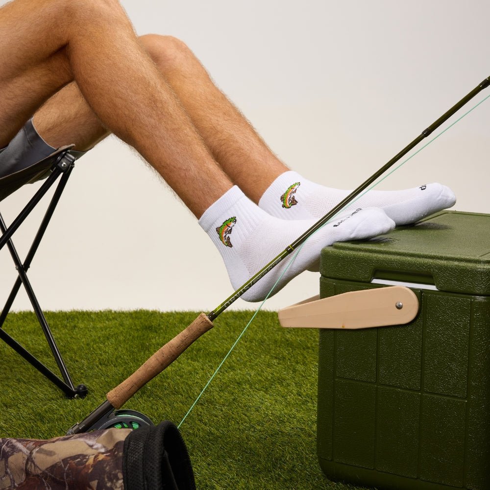 Del Campo Kids Trout socks worn with a fly rod resting on a cooler