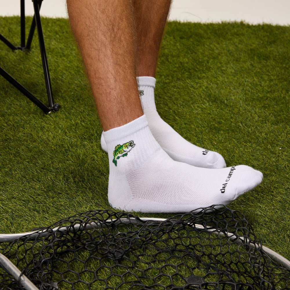 Close-up of Del Campo Largemouth Bass socks worn on a fishing landing net