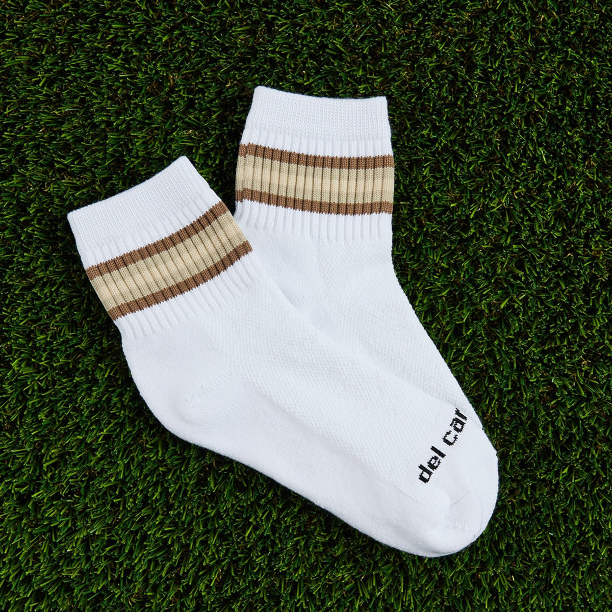 Del Campo Oatmeal 5 Stripe golf socks, flat lay on grass