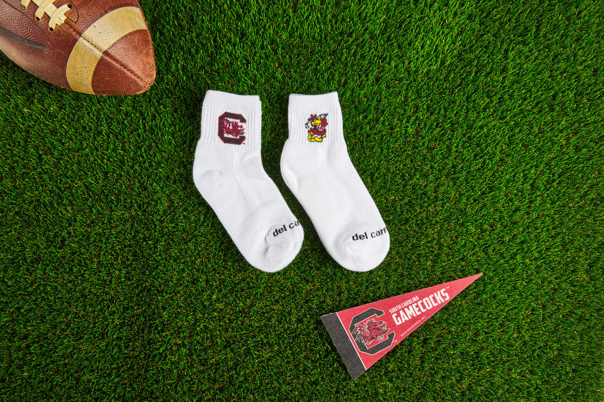 Officially licensed Del Campo South Carolina Gamecocks socks laid out on turf.