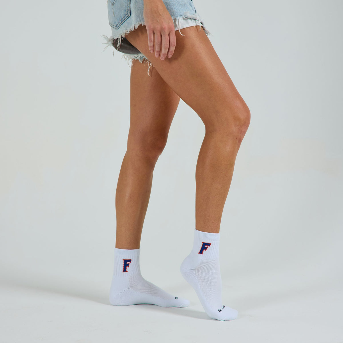 Woman wearing Del Campo Florida Gators Block F golf socks, studio shot, no shoes