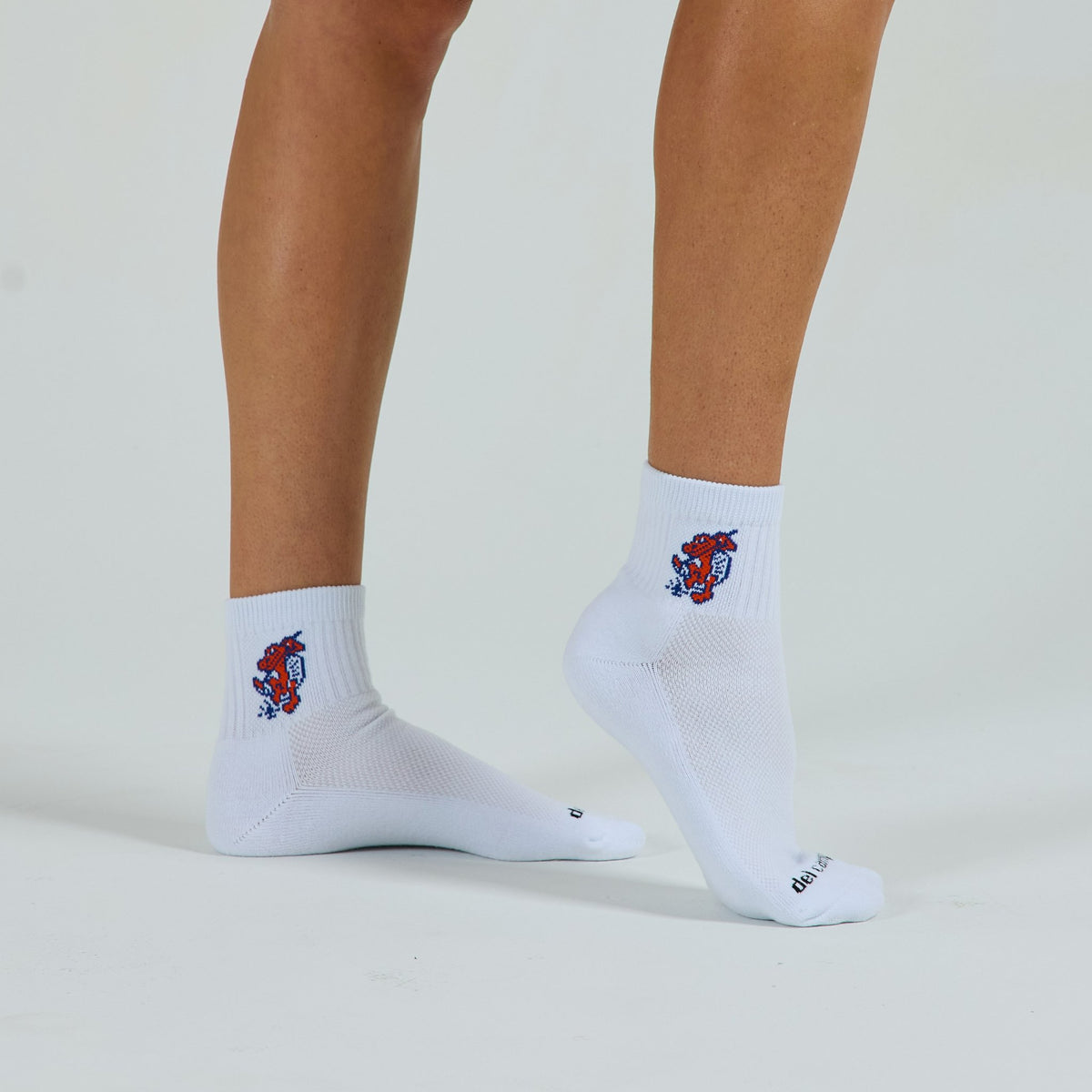 Woman wearing Del Campo Florida Gators Swinging Gator golf socks, studio shot, no shoes