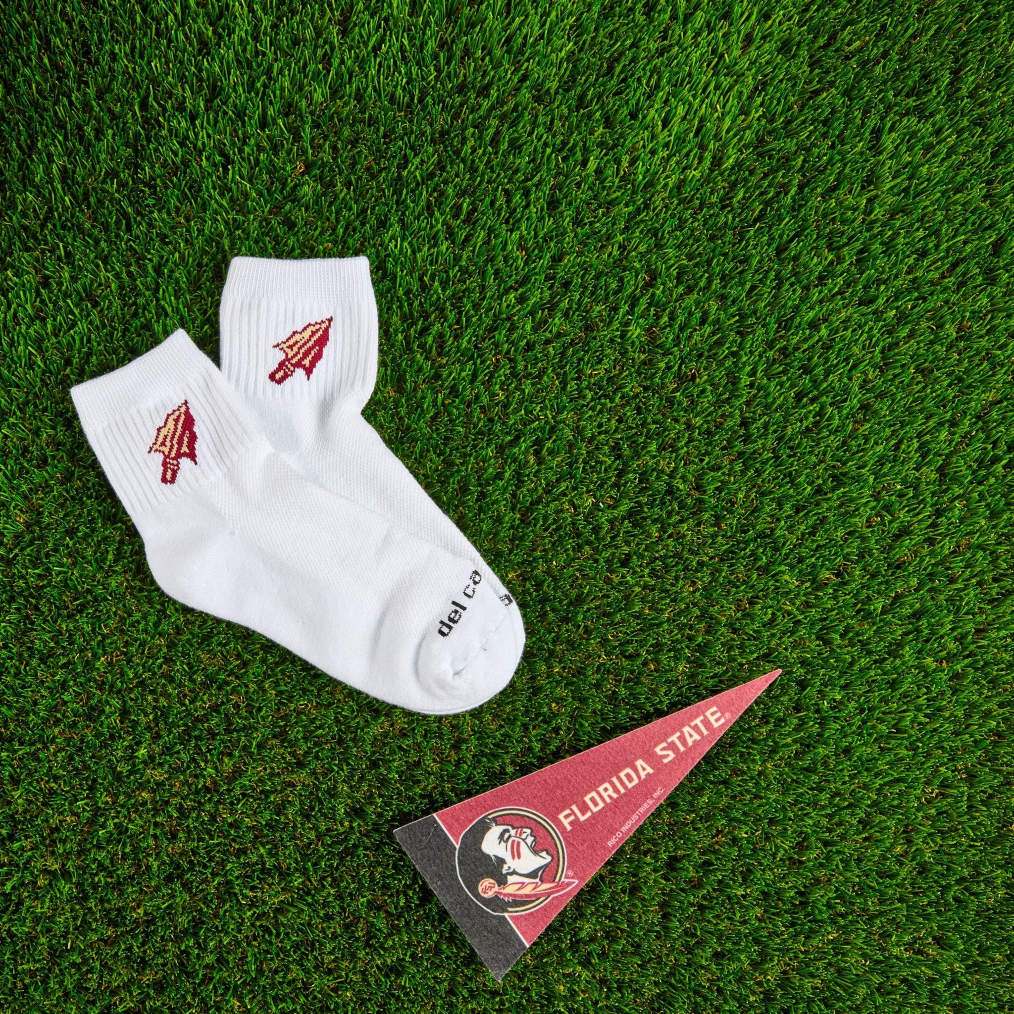 Del Campo Florida State Spear golf socks on turf with a team pennant
