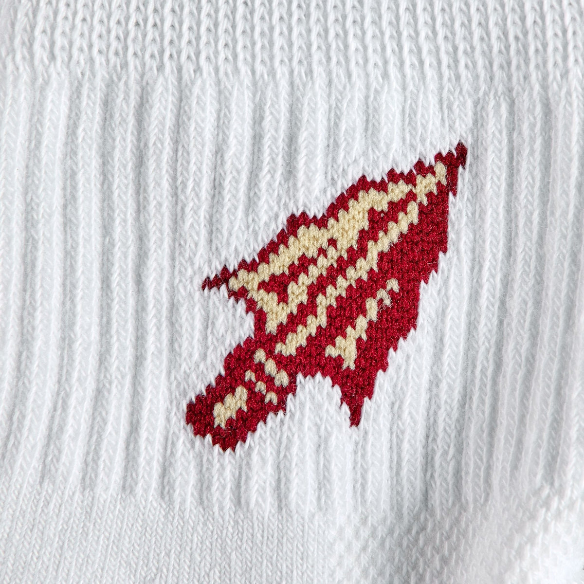 Close-up of the garnet and gold Seminole spear-arrowhead on Del Campo Florida State Spear golf socks
