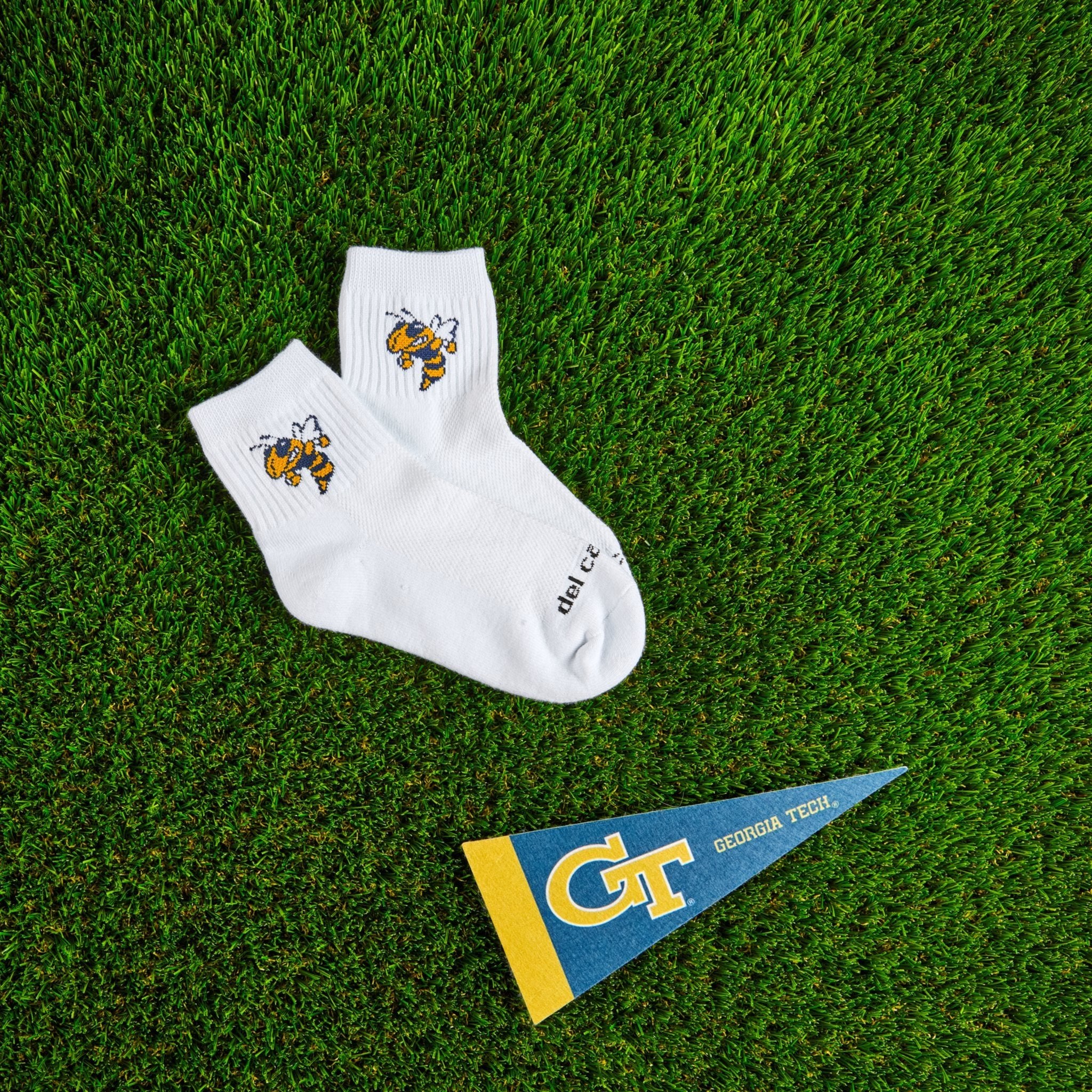 Del Campo Georgia Tech Buzz golf socks on turf with a team pennant