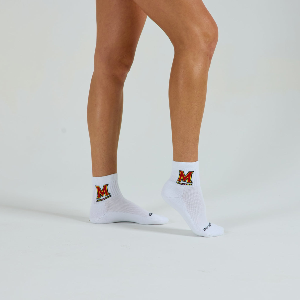 Woman wearing Del Campo Maryland Terrapins golf socks, studio shot, no shoes