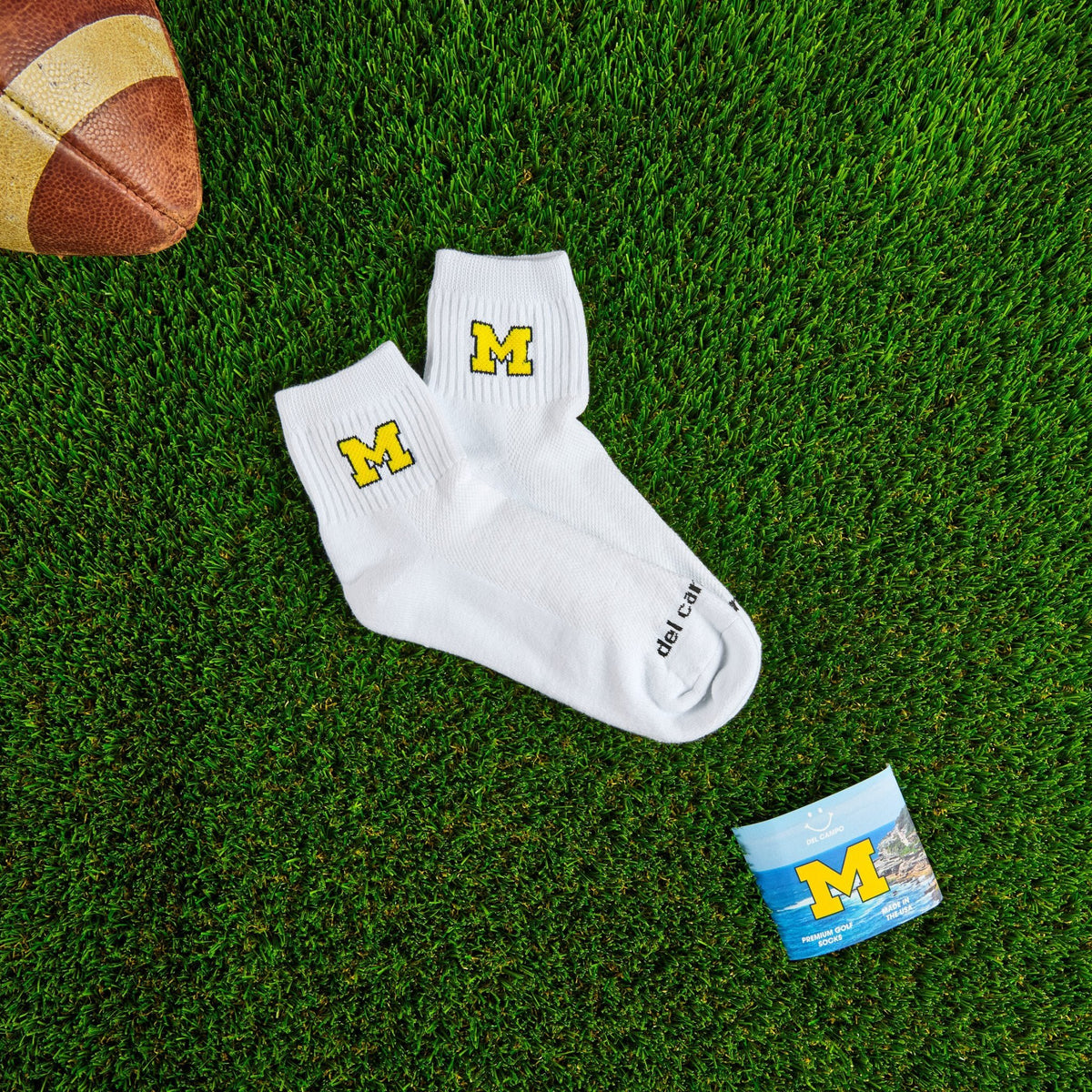 Del Campo Michigan Maize golf socks on turf with a team pennant