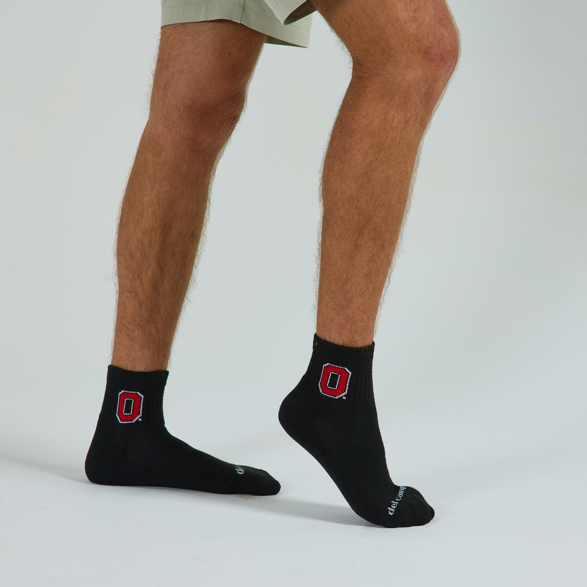 Man wearing Del Campo Ohio State Night Mode golf socks, studio shot, no shoes