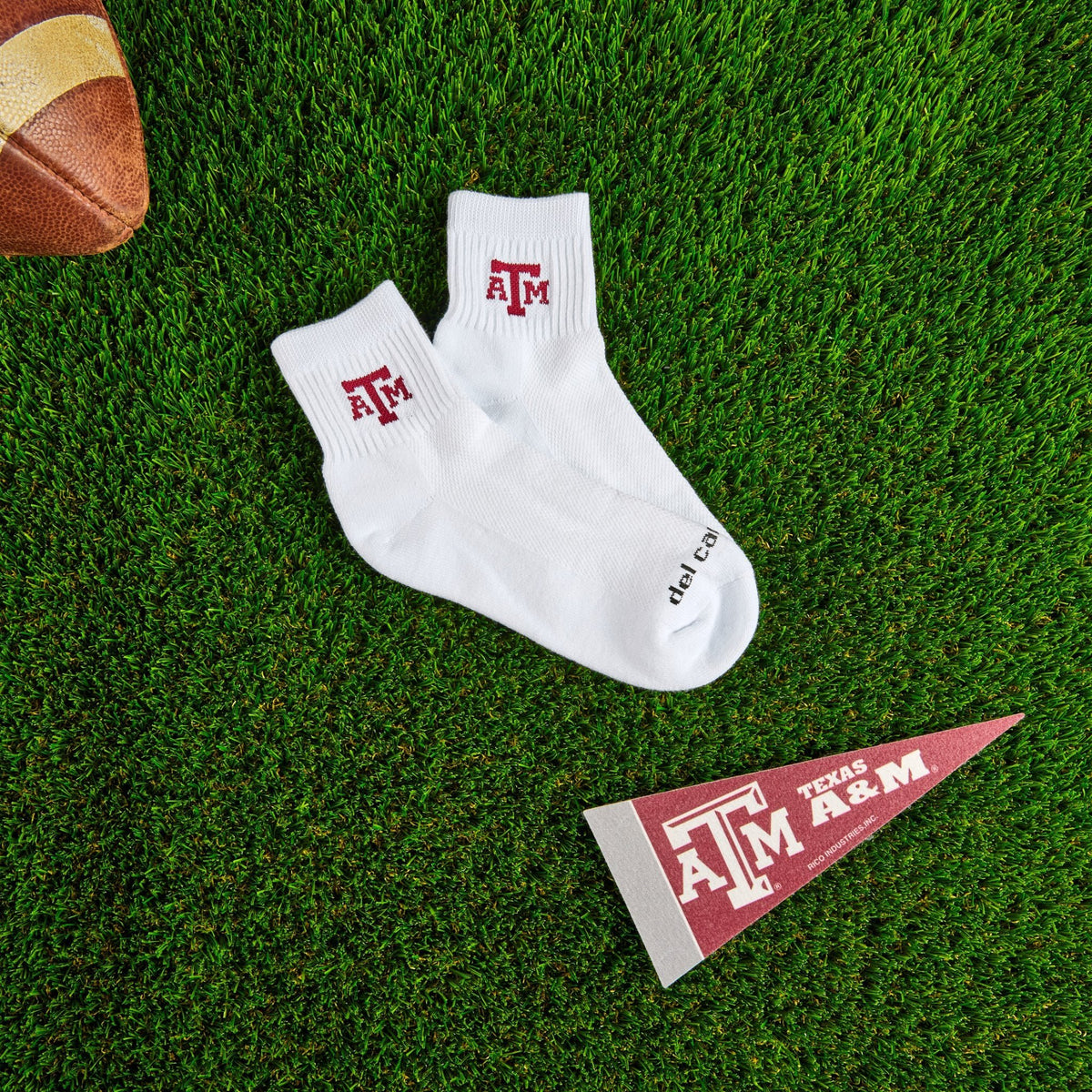 Del Campo Texas A&M Aggies golf socks on turf with a team pennant