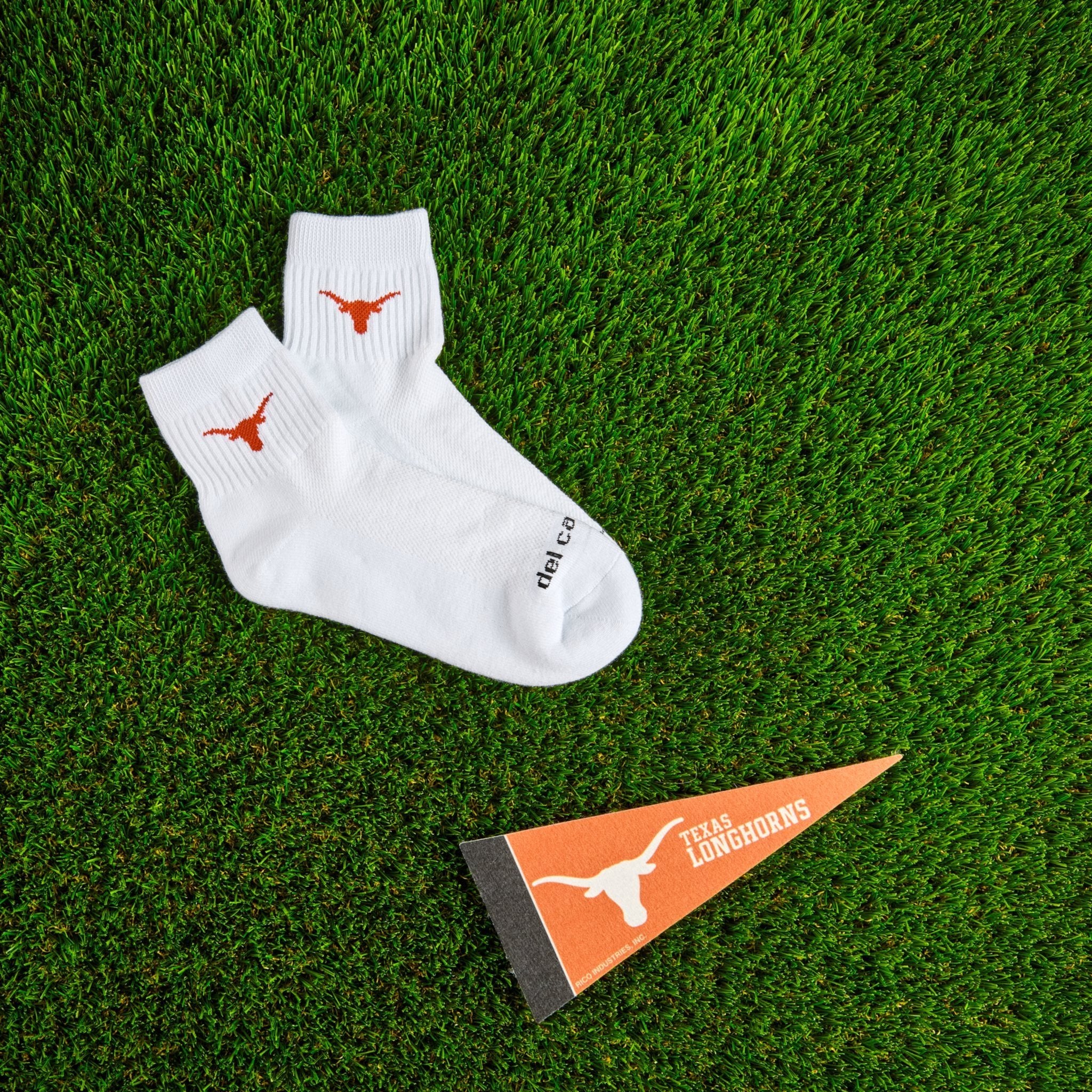 Del Campo Texas Longhorns golf socks on turf with a team pennant
