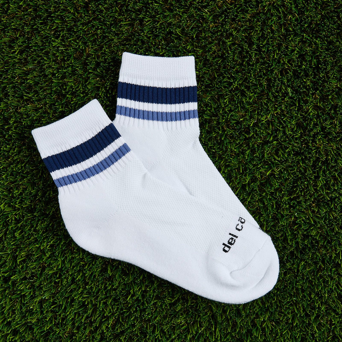 Del Campo Navy Stripes golf socks, flat lay on grass