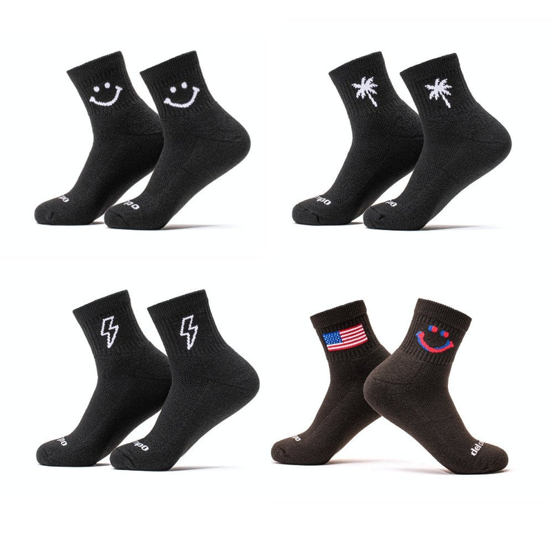 Del Campo Golf Night Mode Pack with four black socks featuring smiley face, palm tree, lightning bolt, and American flag designs. | product