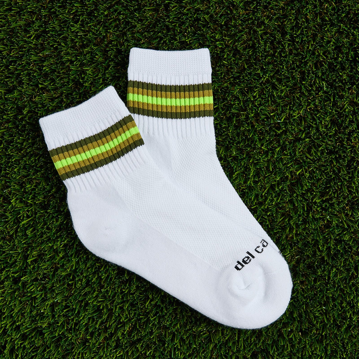 Del Campo Forest 5 Stripe golf socks, flat lay on grass