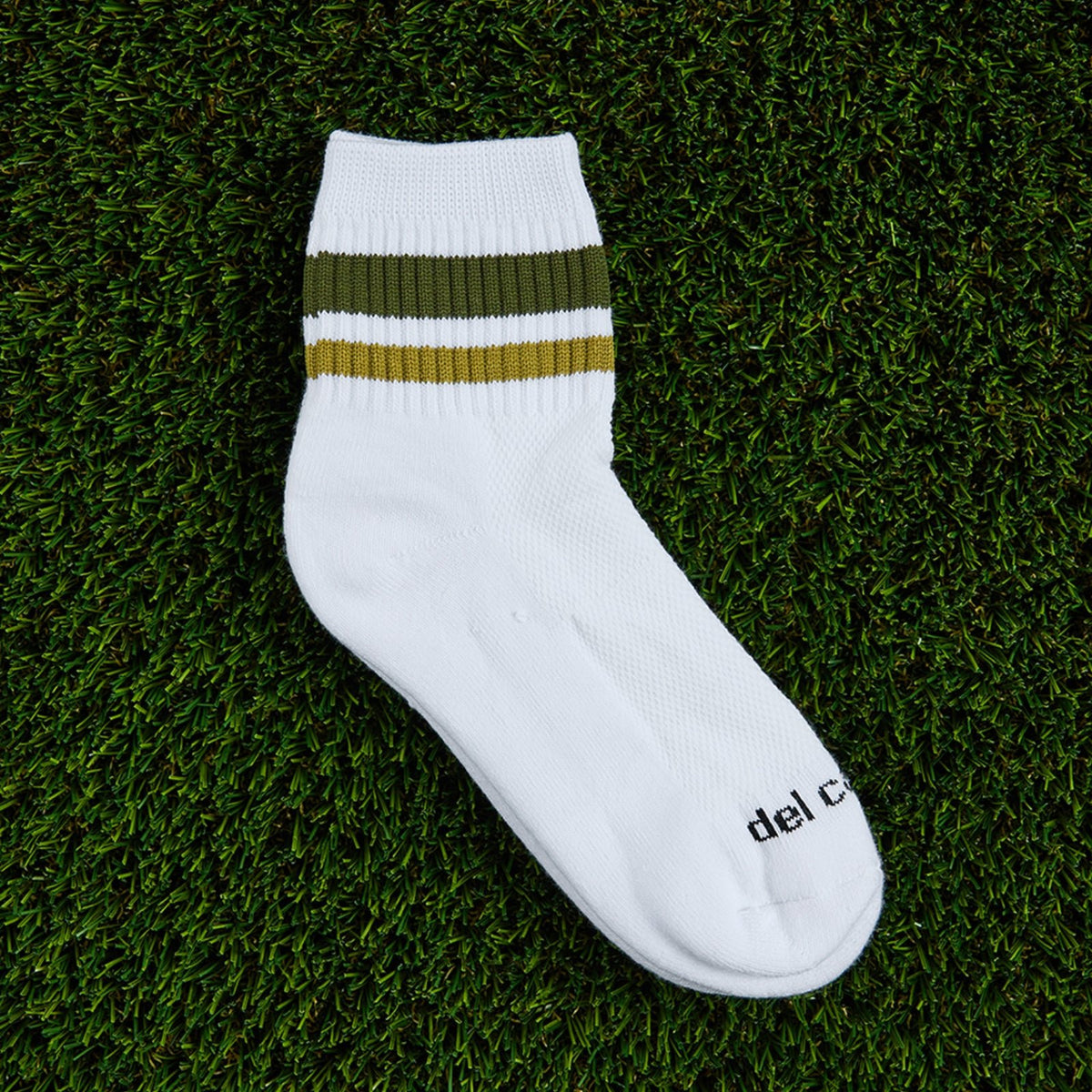 Del Campo Forest Stripes golf socks, flat lay on grass