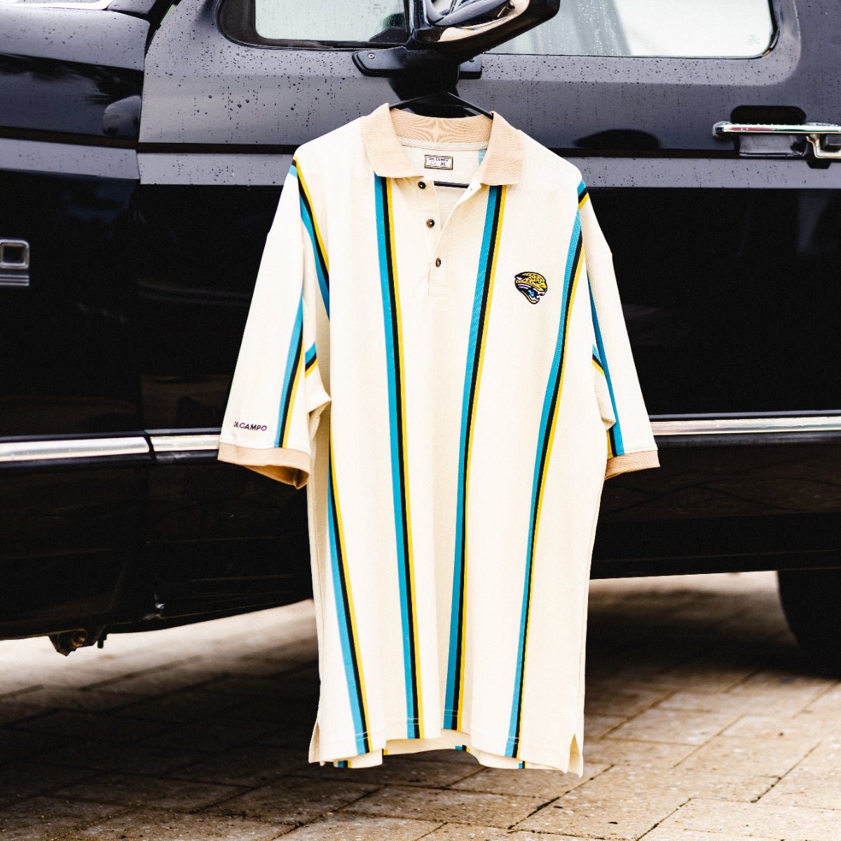 Lot J Polo, officially licensed Jacksonville Jaguars cream polo with teal and gold stripes by Del Campo