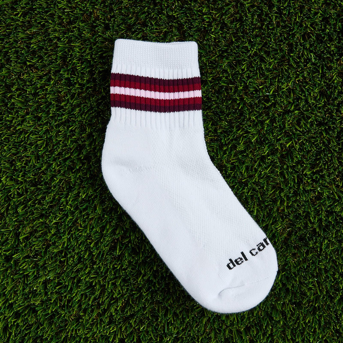 Del Campo Cardinal 5 Stripe golf socks, flat lay on grass