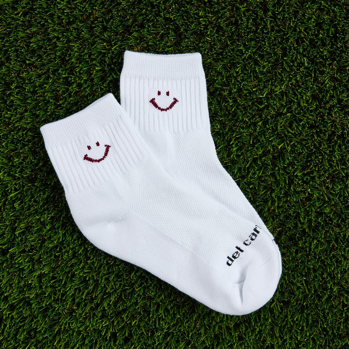 Del Campo Cardinal Smiley golf socks, flat lay on grass