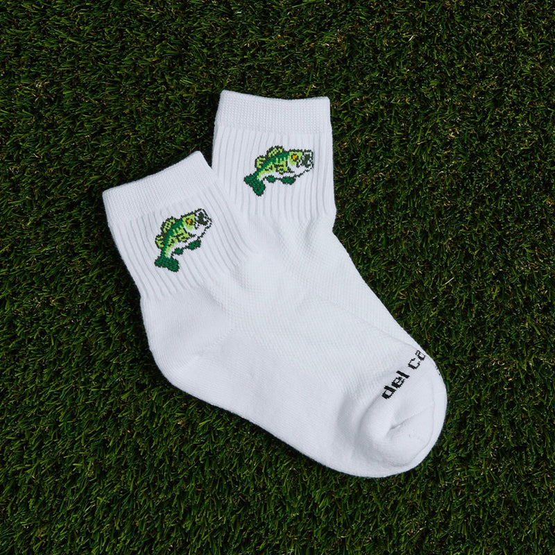 Del Campo Largemouth Bass socks with green embroidered bass, laid on grass