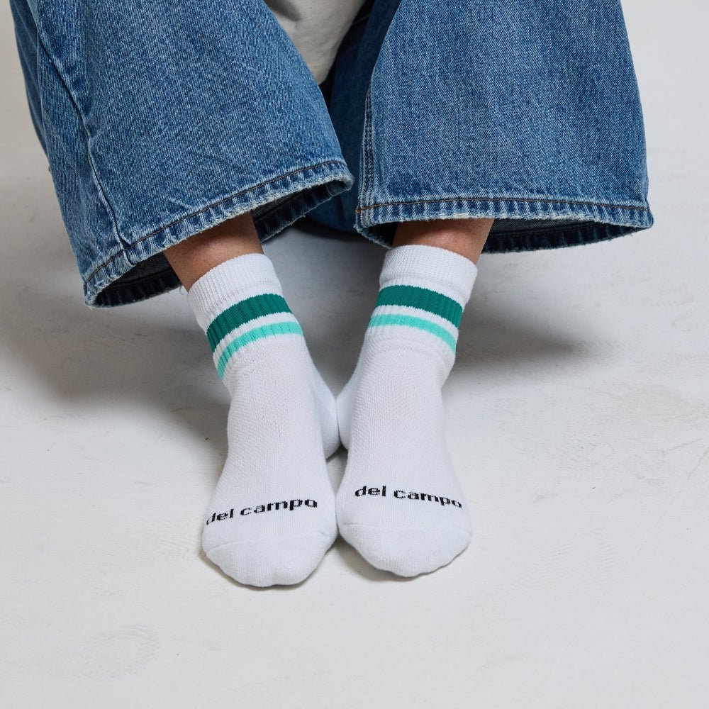 Del Campo Golf Seaside Stripes socks worn with jeans, featuring white base with green and mint stripes. | lifestyle