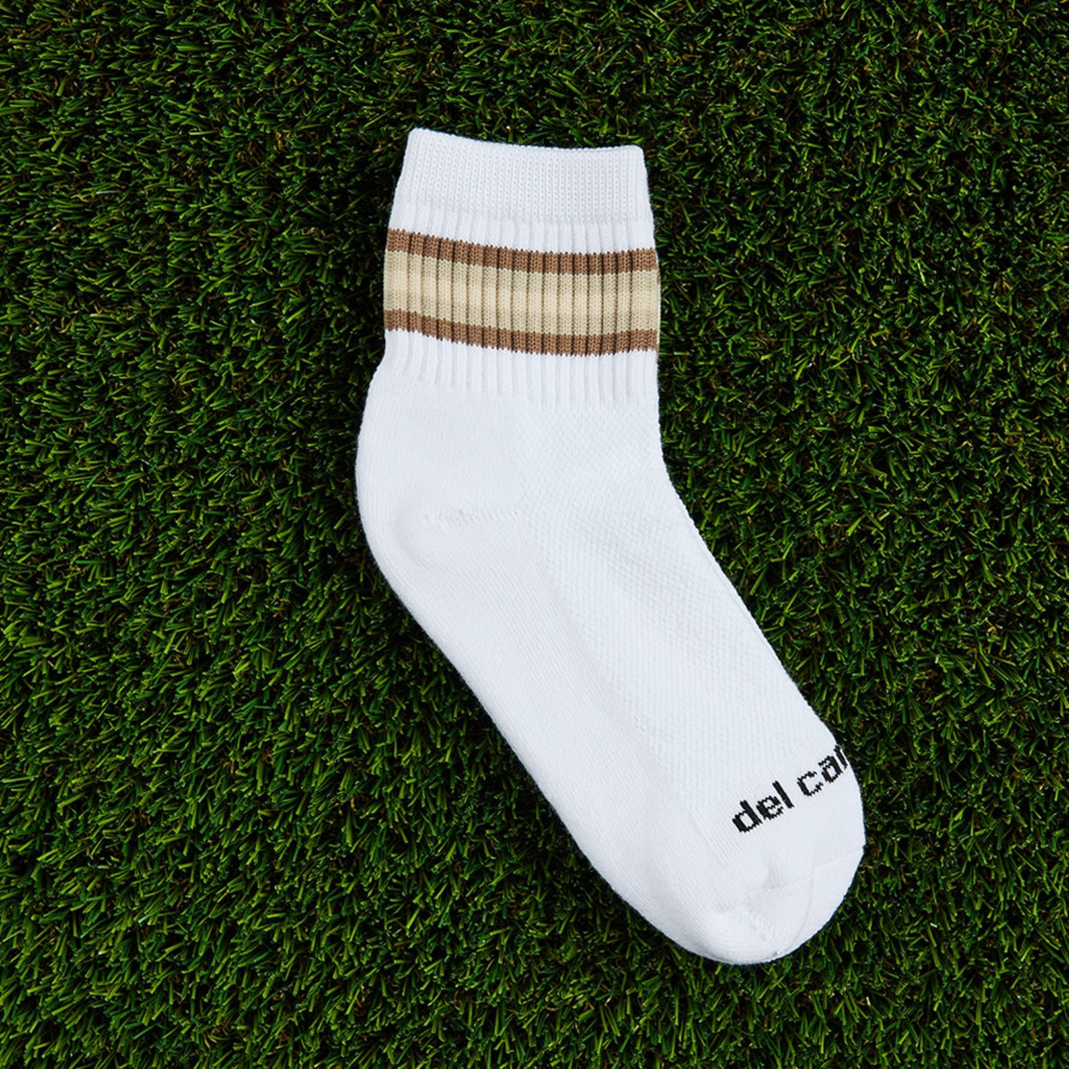 Del Campo Oatmeal 5 Stripe golf socks, flat lay on grass