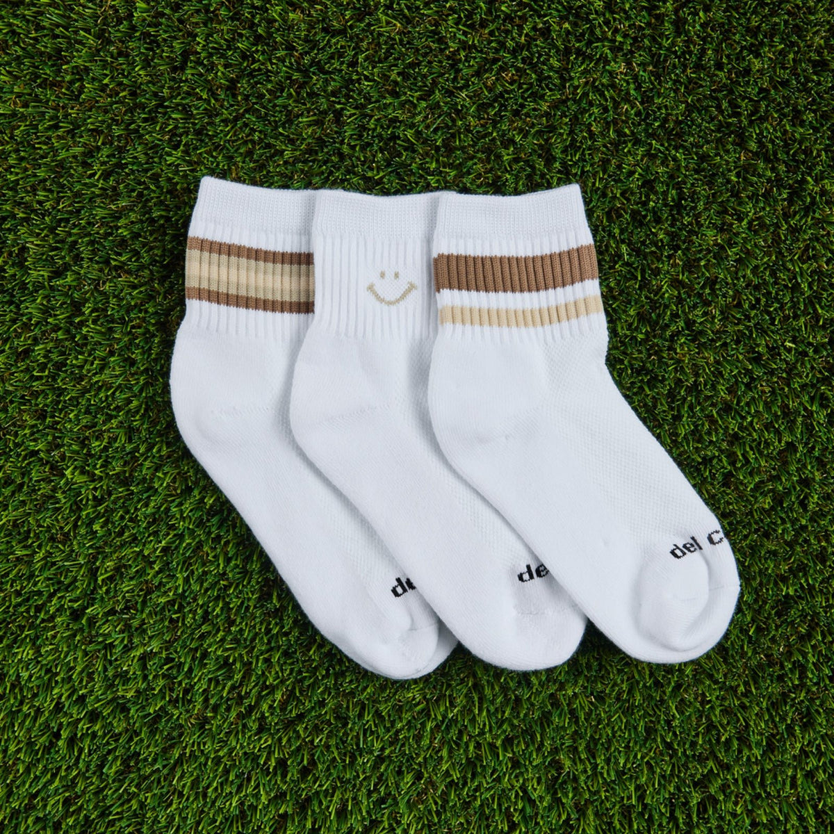 Del Campo Fall Oatmeal Pack golf socks, pack flat lay on grass
