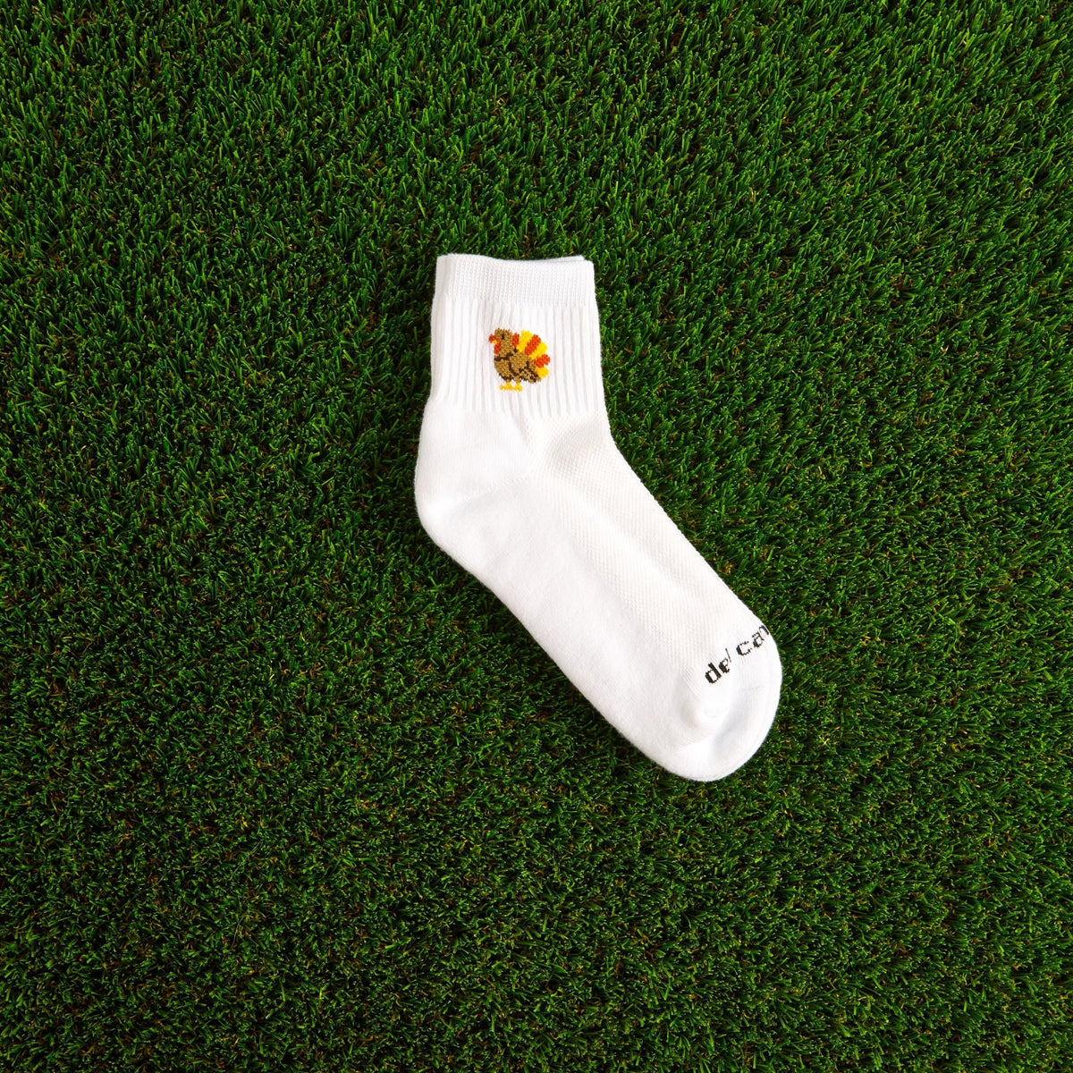 Del Campo Turkey Boys Thanksgiving golf socks, white quarter socks with a knit turkey, single sock on grass