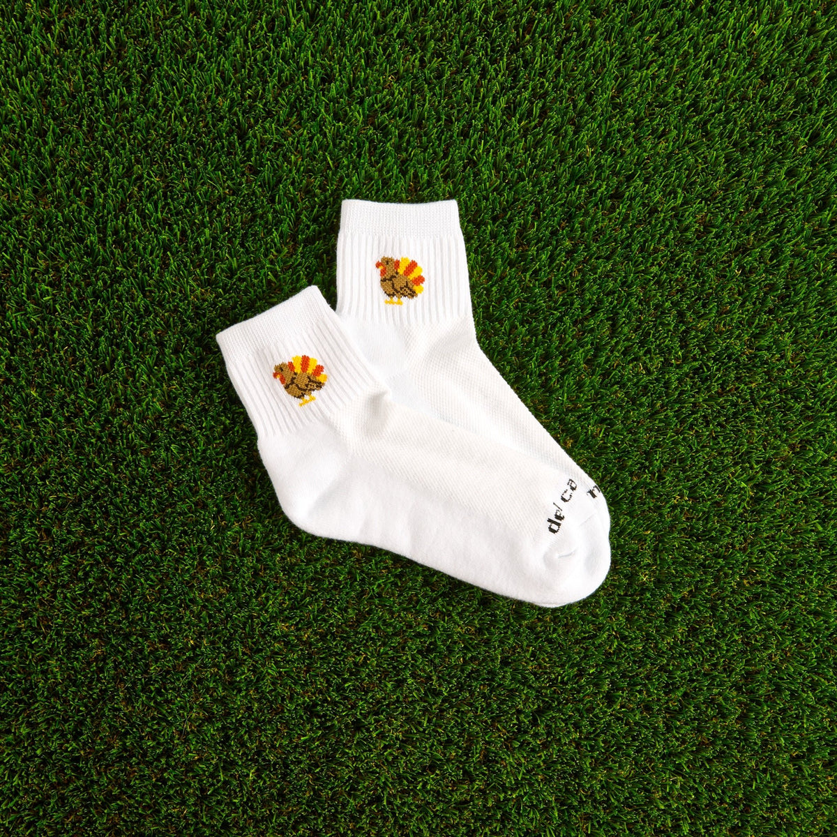 Del Campo Turkey Boys Thanksgiving golf socks, white quarter socks with a knit turkey, pair on grass