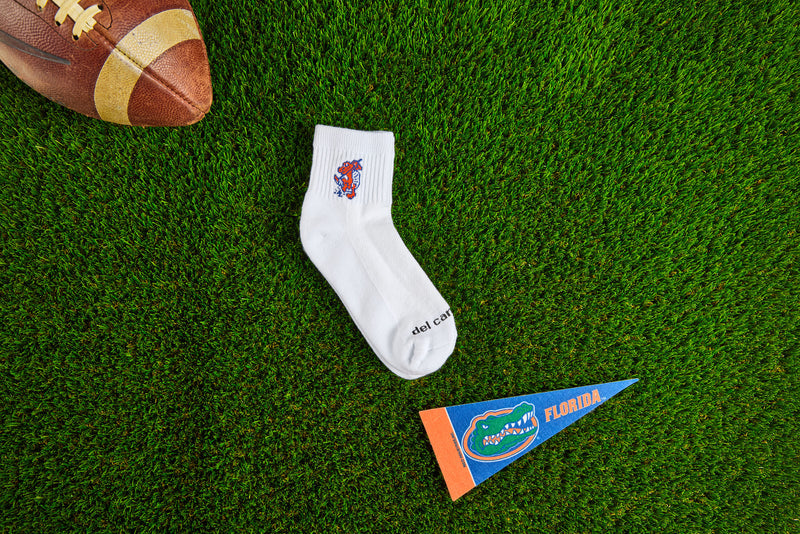 Officially licensed Del Campo Florida Gators socks laid out on turf.