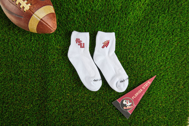 Officially licensed Del Campo Florida State Seminoles socks laid out on turf.
