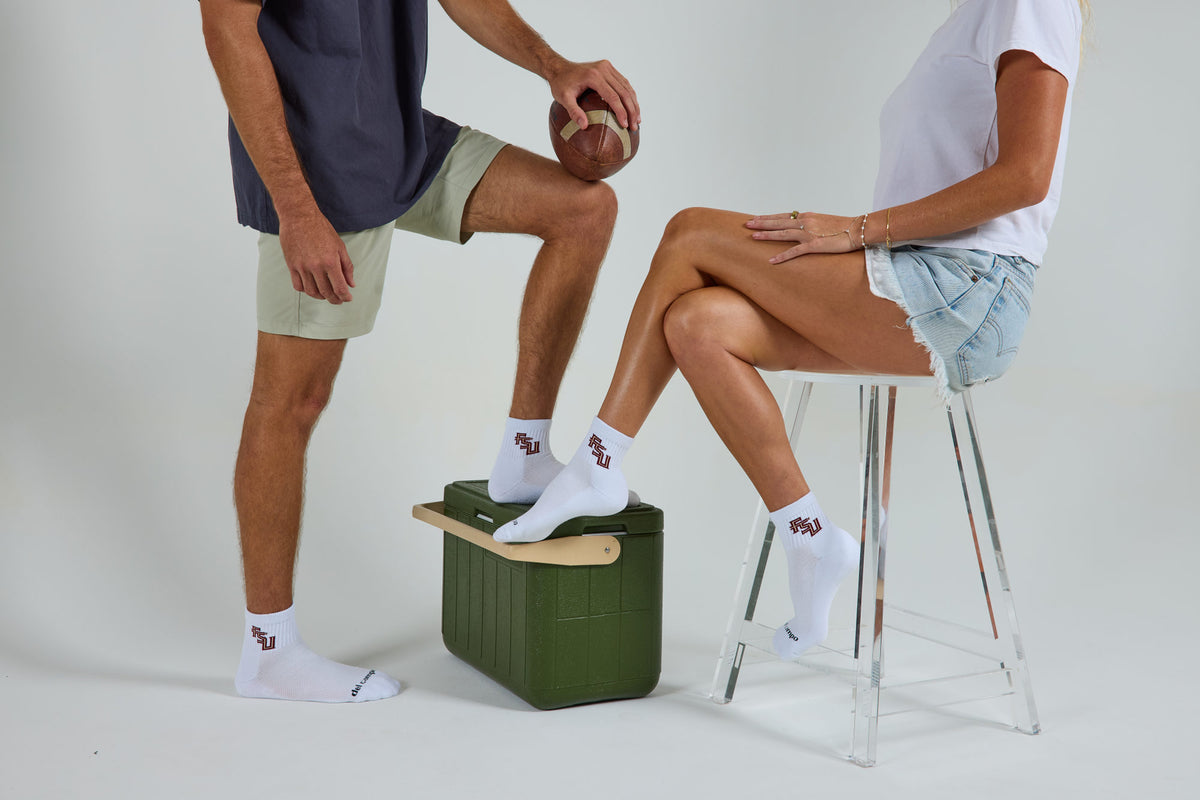 A man and a woman wearing officially licensed Del Campo Florida State Seminoles socks.