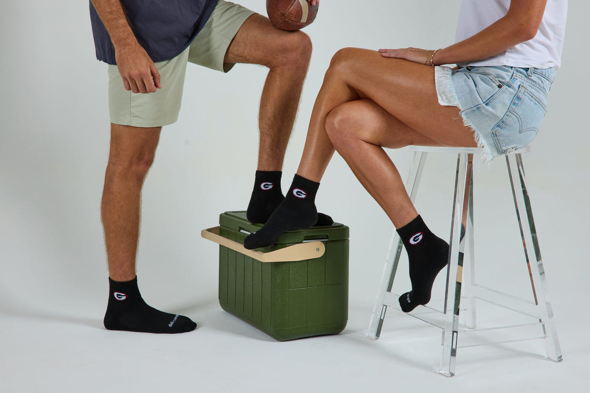 A man and a woman wearing officially licensed Del Campo Georgia Bulldogs socks.