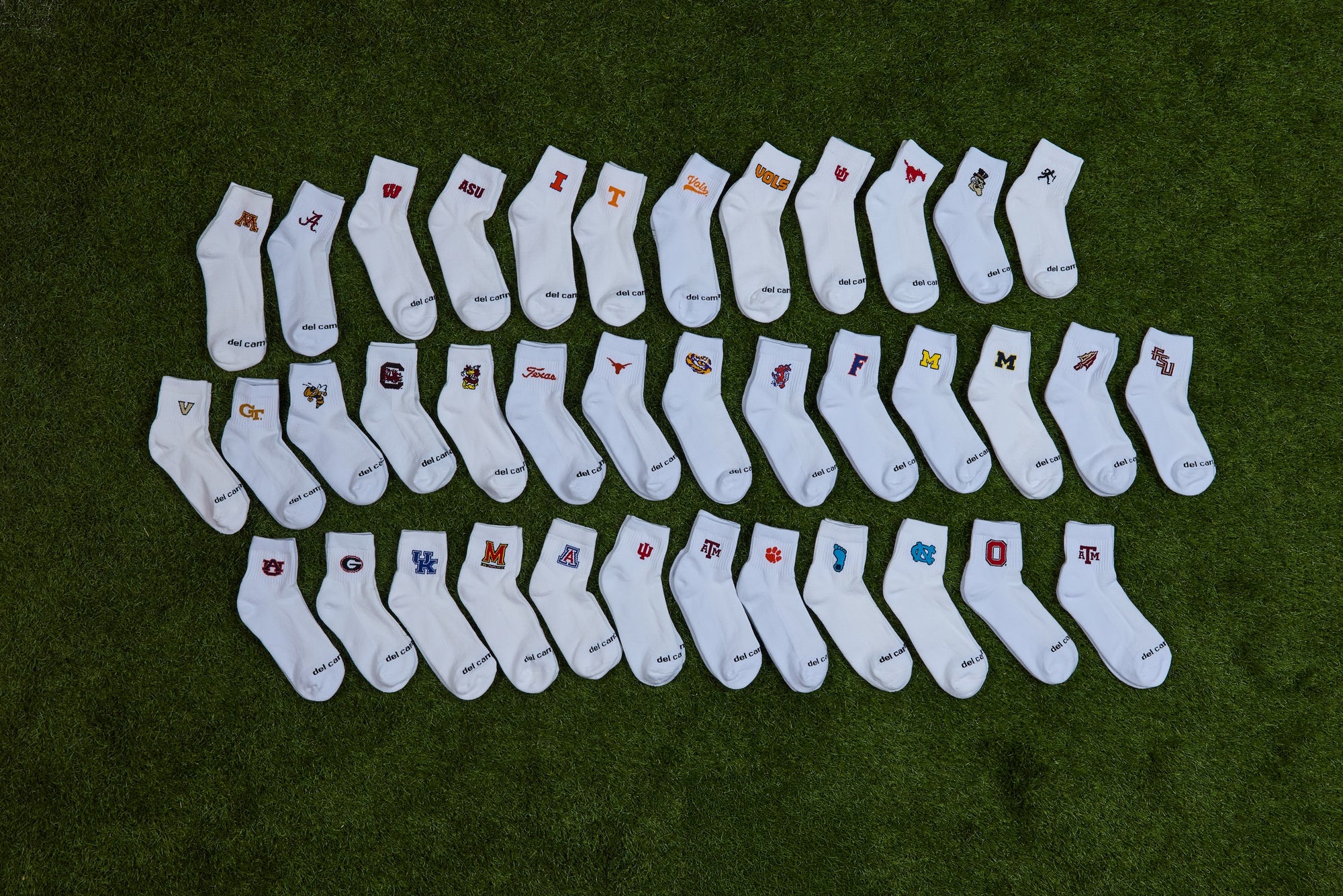Del Campo officially licensed college socks laid out on turf