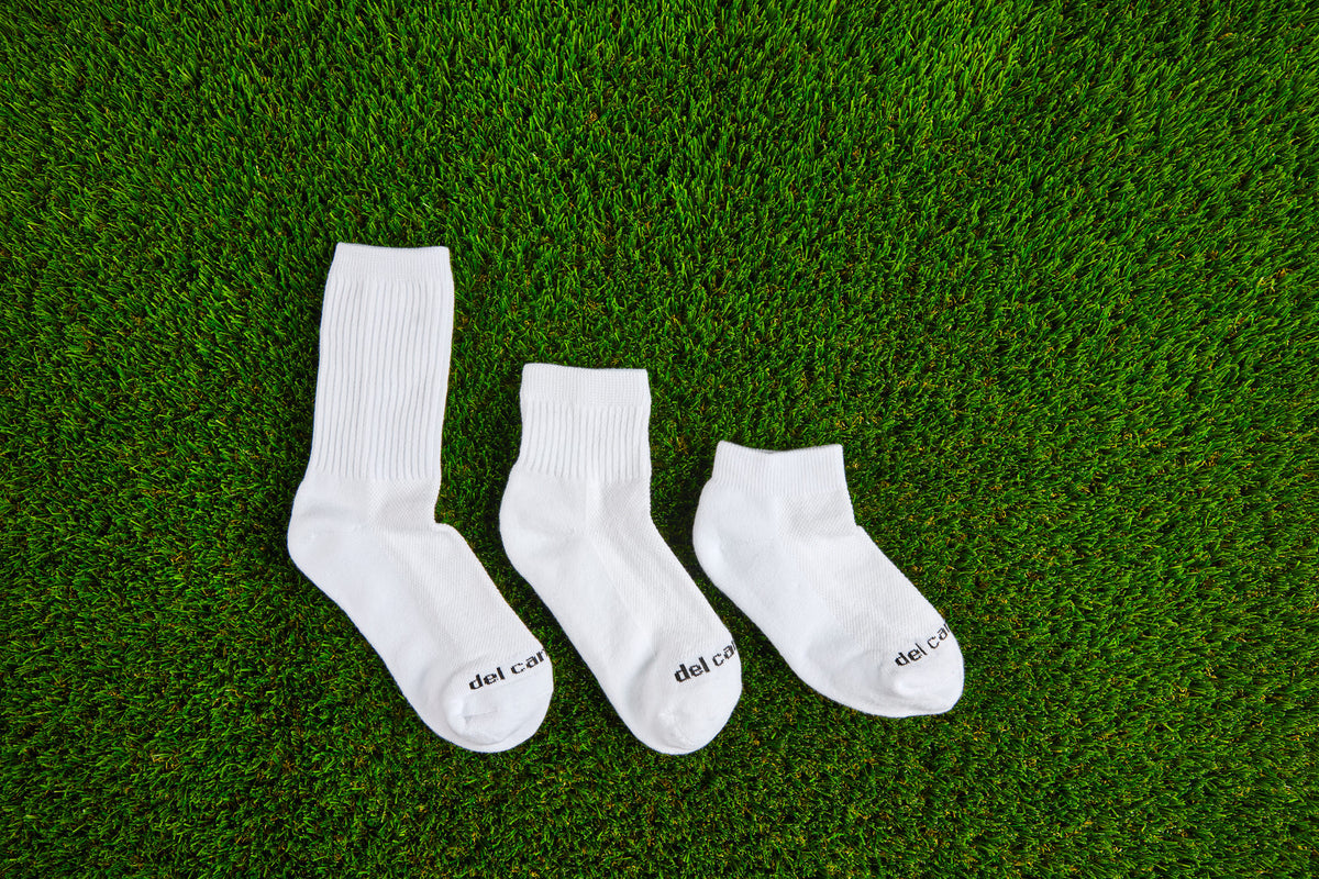 Three Del Campo socks on turf, crew, quarter and low cut. Made in America.