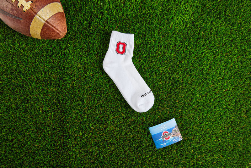 Officially licensed Del Campo Ohio State Buckeyes socks laid out on turf.