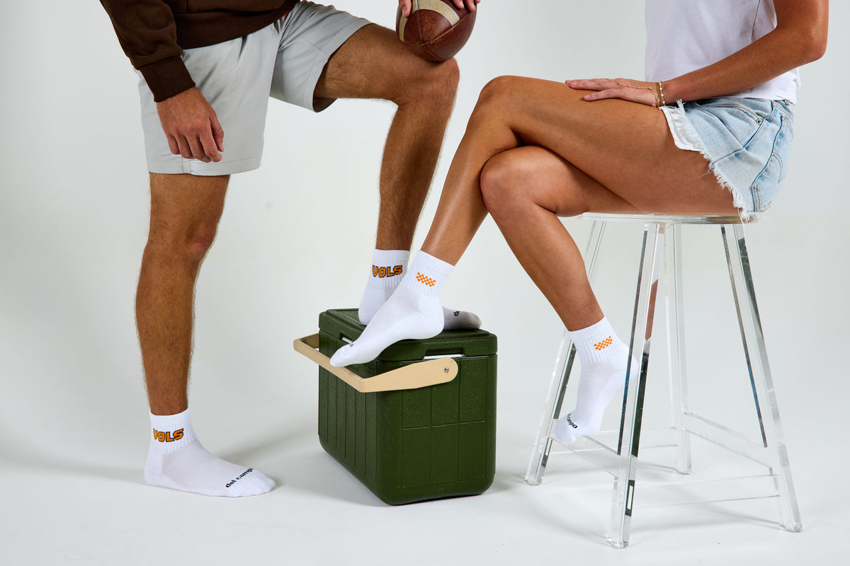 A man and a woman wearing officially licensed Del Campo Tennessee Volunteers socks.