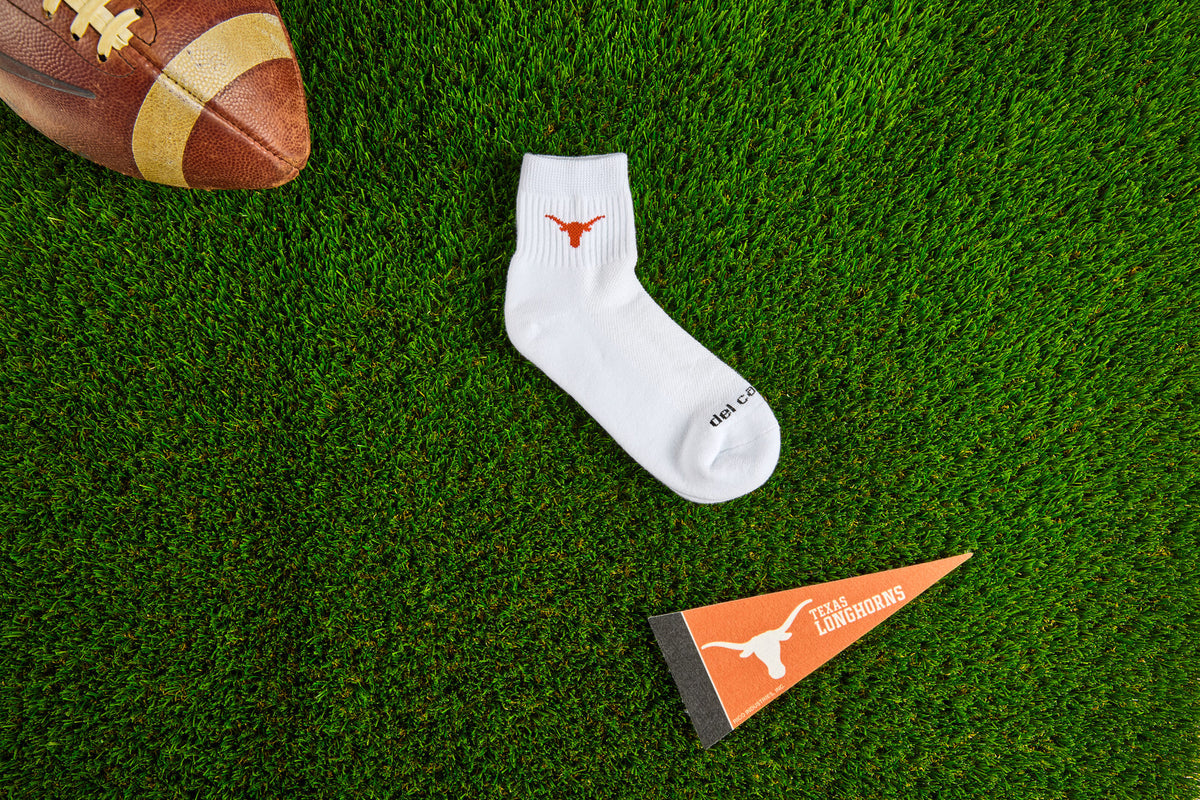 Del Campo Texas Longhorns socks on the turf with a Texas Longhorns pennant. Made in America.