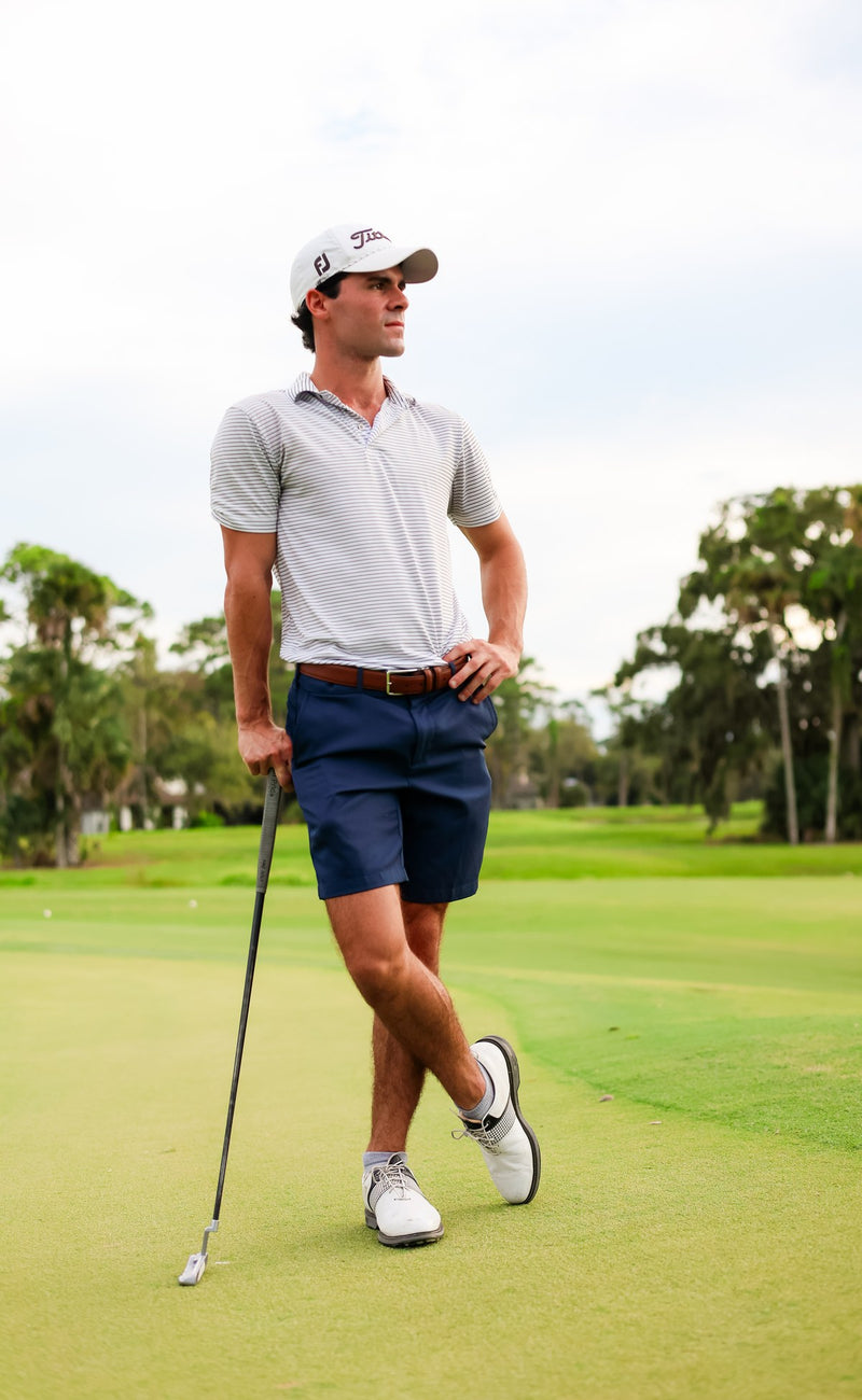 Golfer leaning on his club on the green in grey Del Campo blank socks