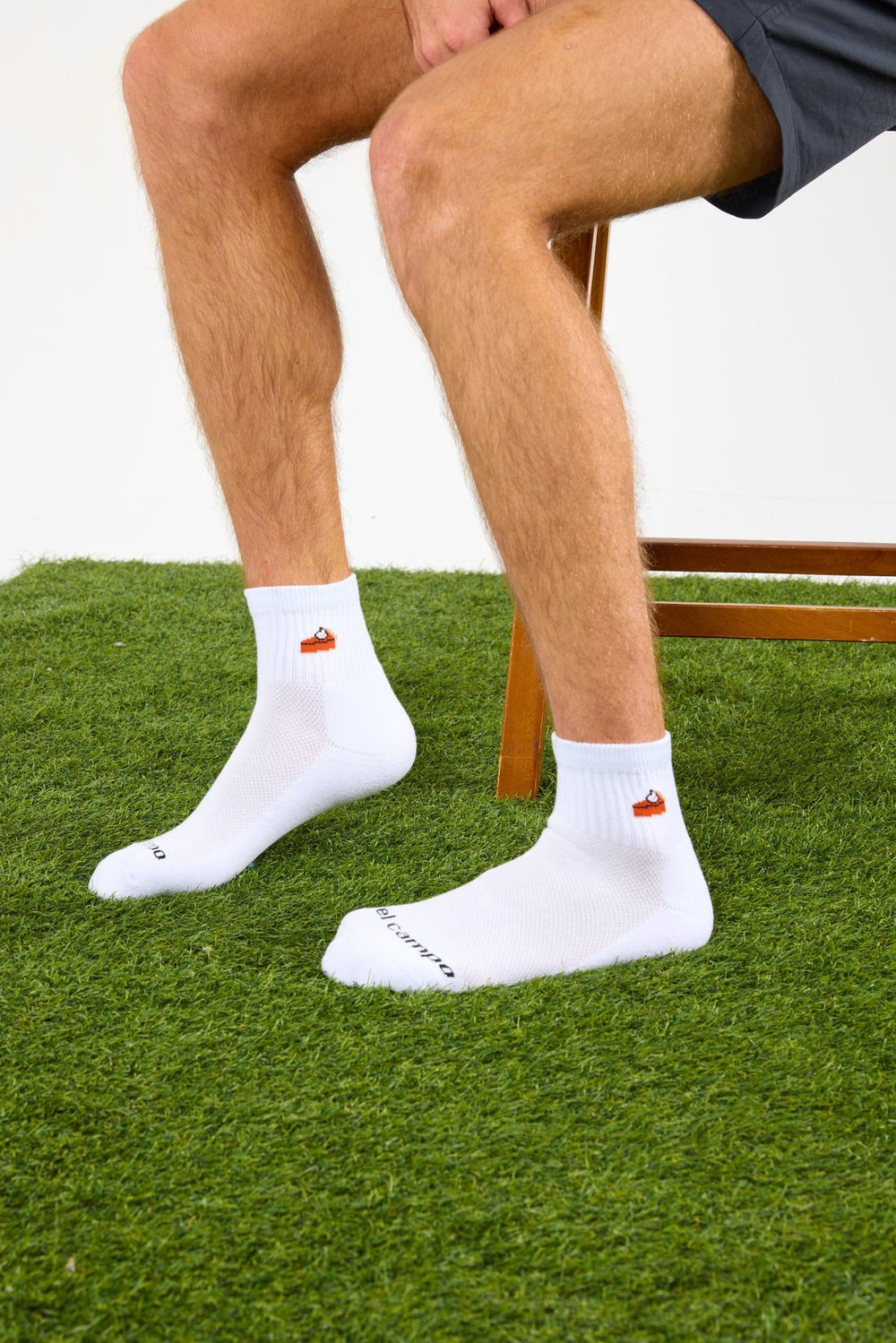 Seated golfer in Del Campo Pumpkin Pie socks on grass
