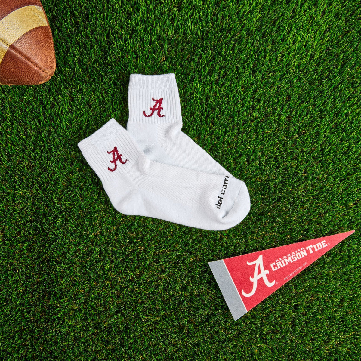 Del Campo Alabama Crimson Tide golf socks on turf with a team pennant