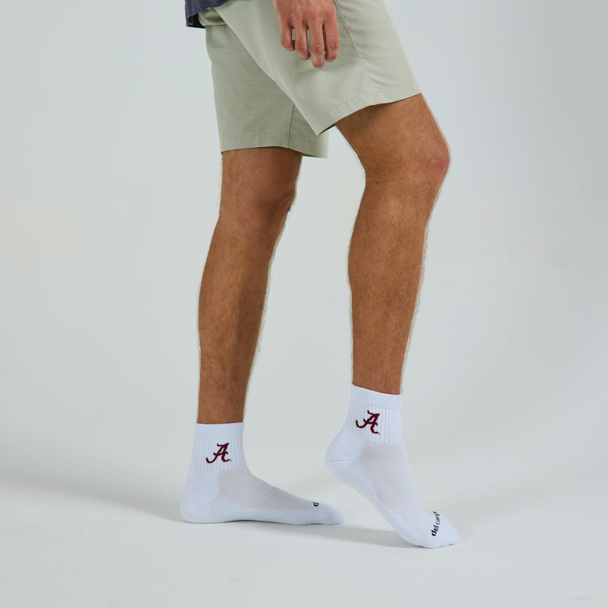 Man wearing Del Campo Alabama Crimson Tide golf socks, studio shot, no shoes