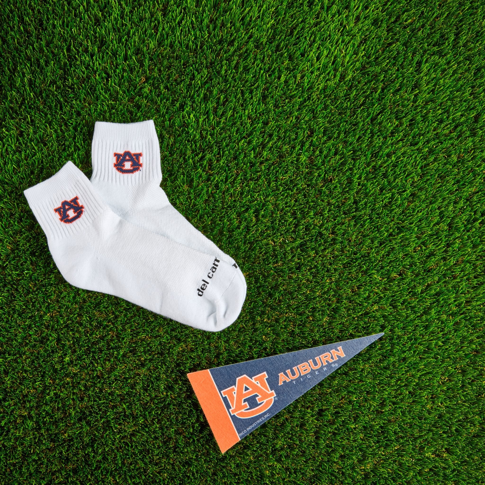 Del Campo Auburn War Eagle golf socks on turf with a team pennant